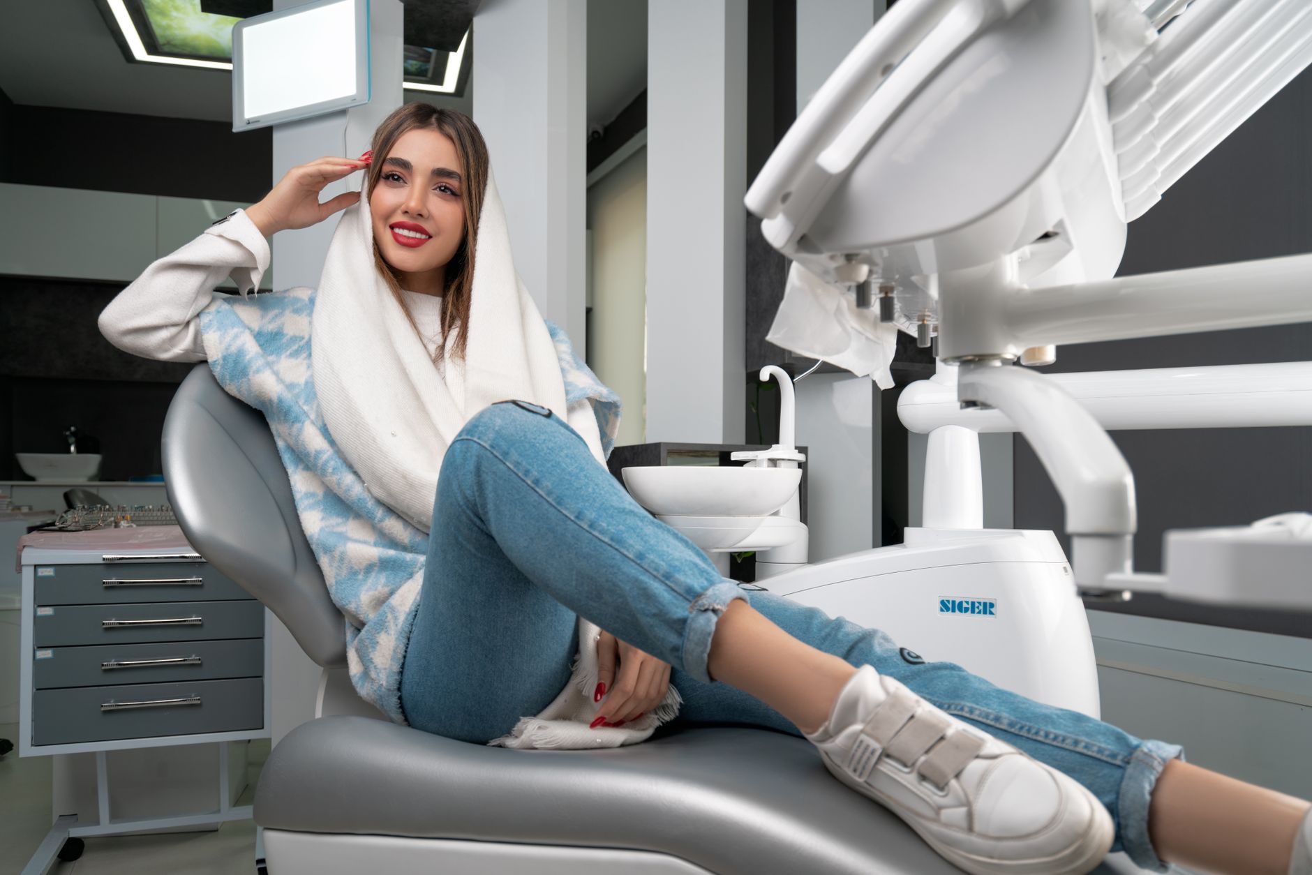 A smiling patient at a Turkish dental clinic, showcasing their new smile in a stylish dental chair.