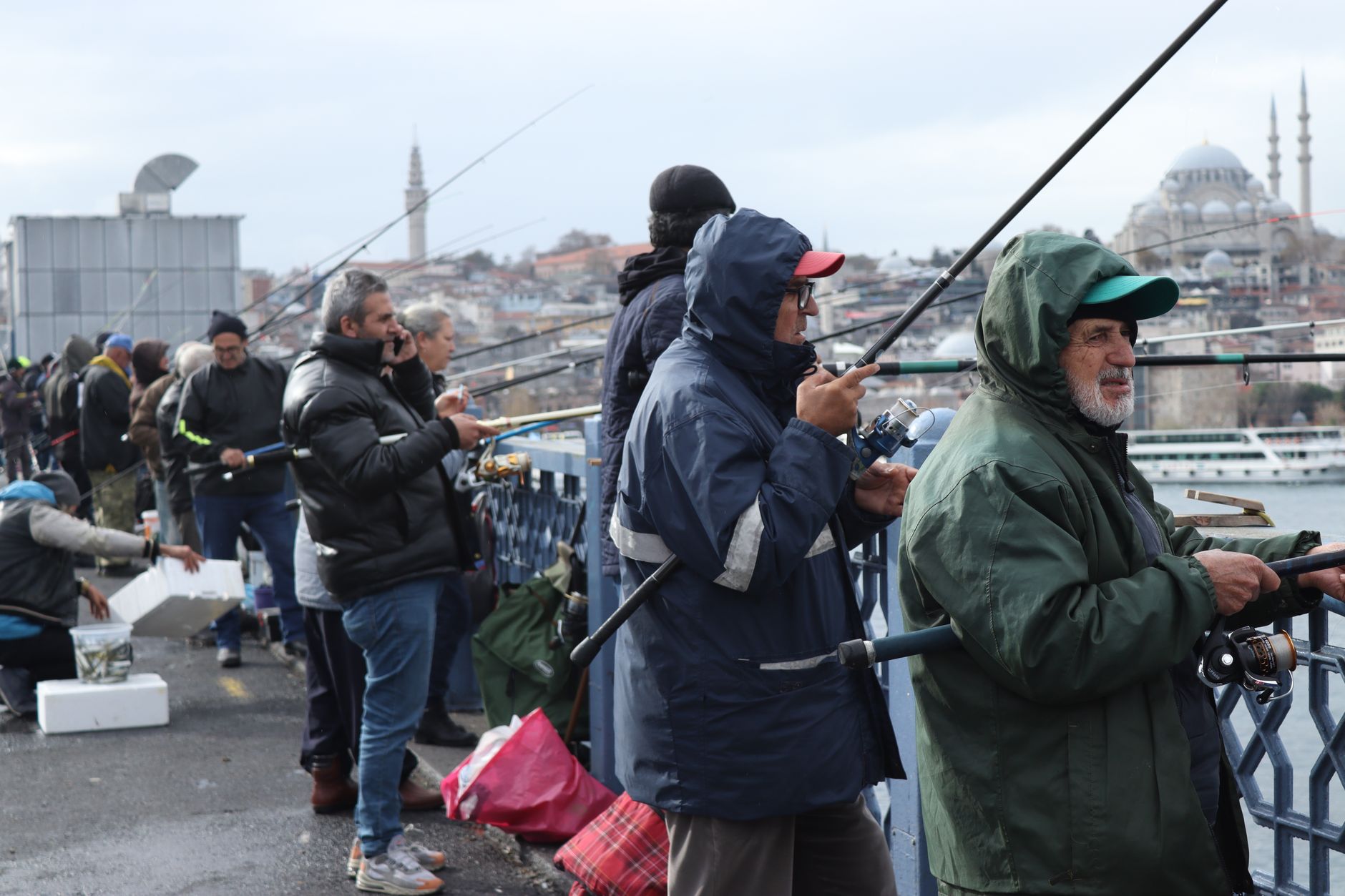 İstanbul'da bir köprüde oltalarını suya atan bir grup balıkçı.