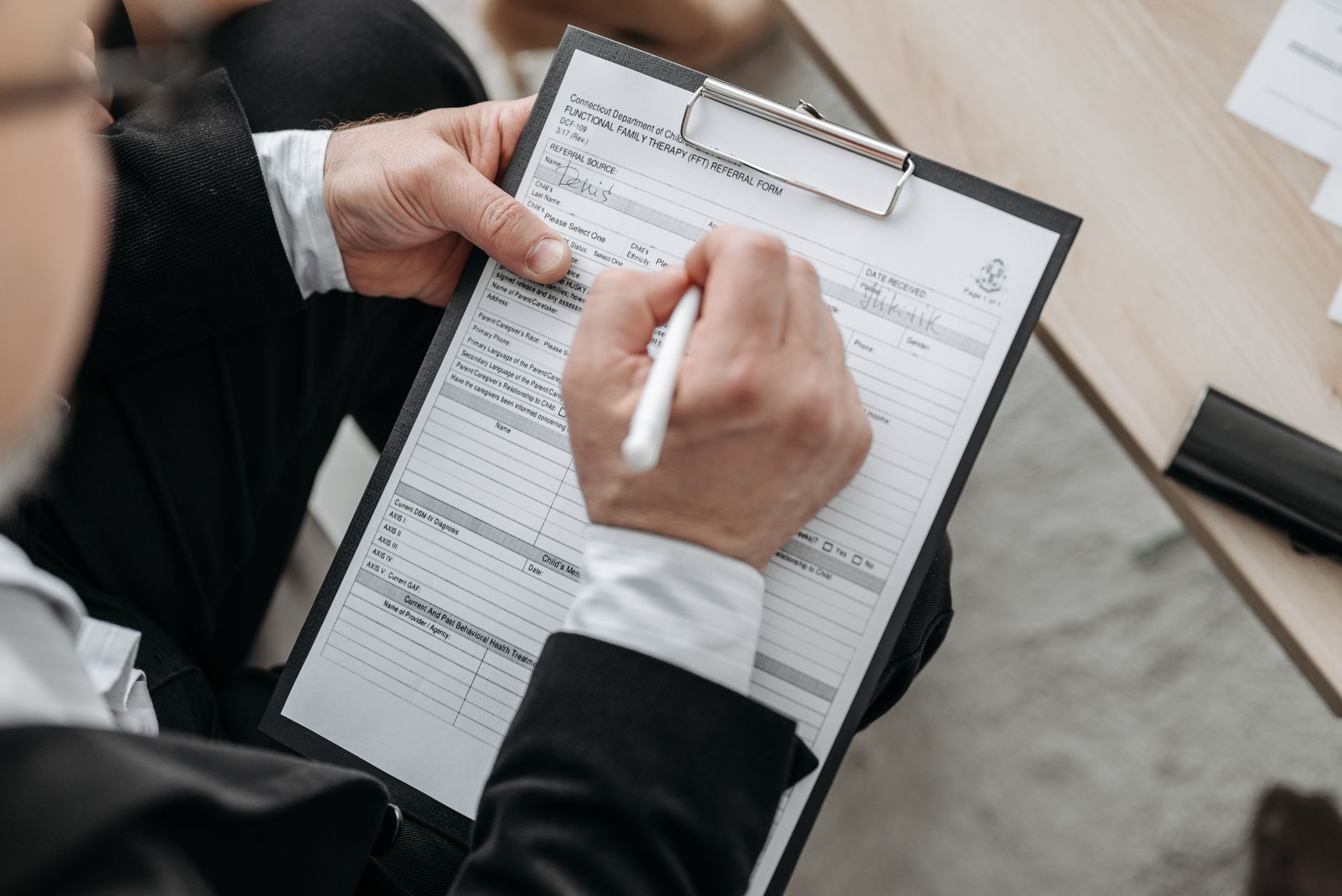 A person filling out a functional family therapy referral form in Connecticut.