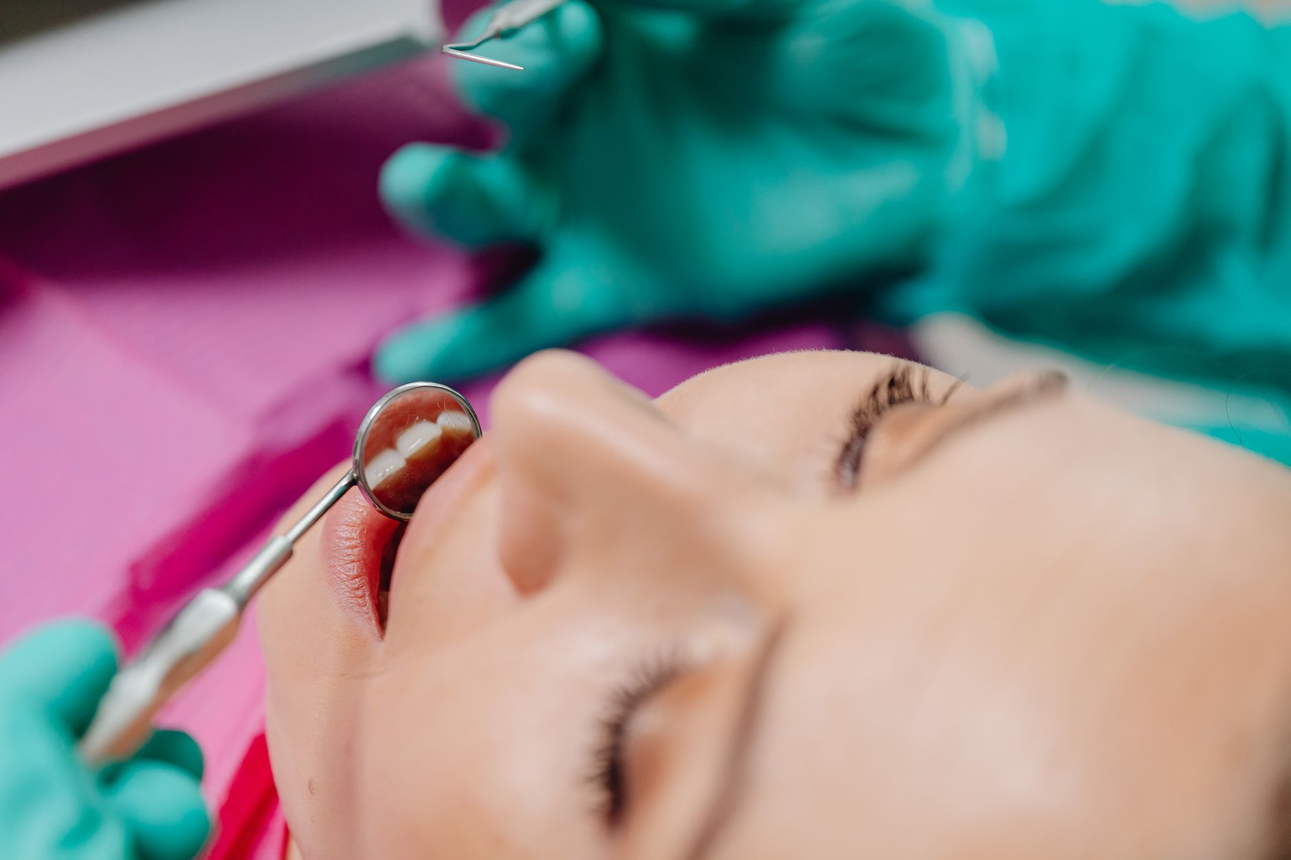 Dental patient receiving an oral examination with dental tools.