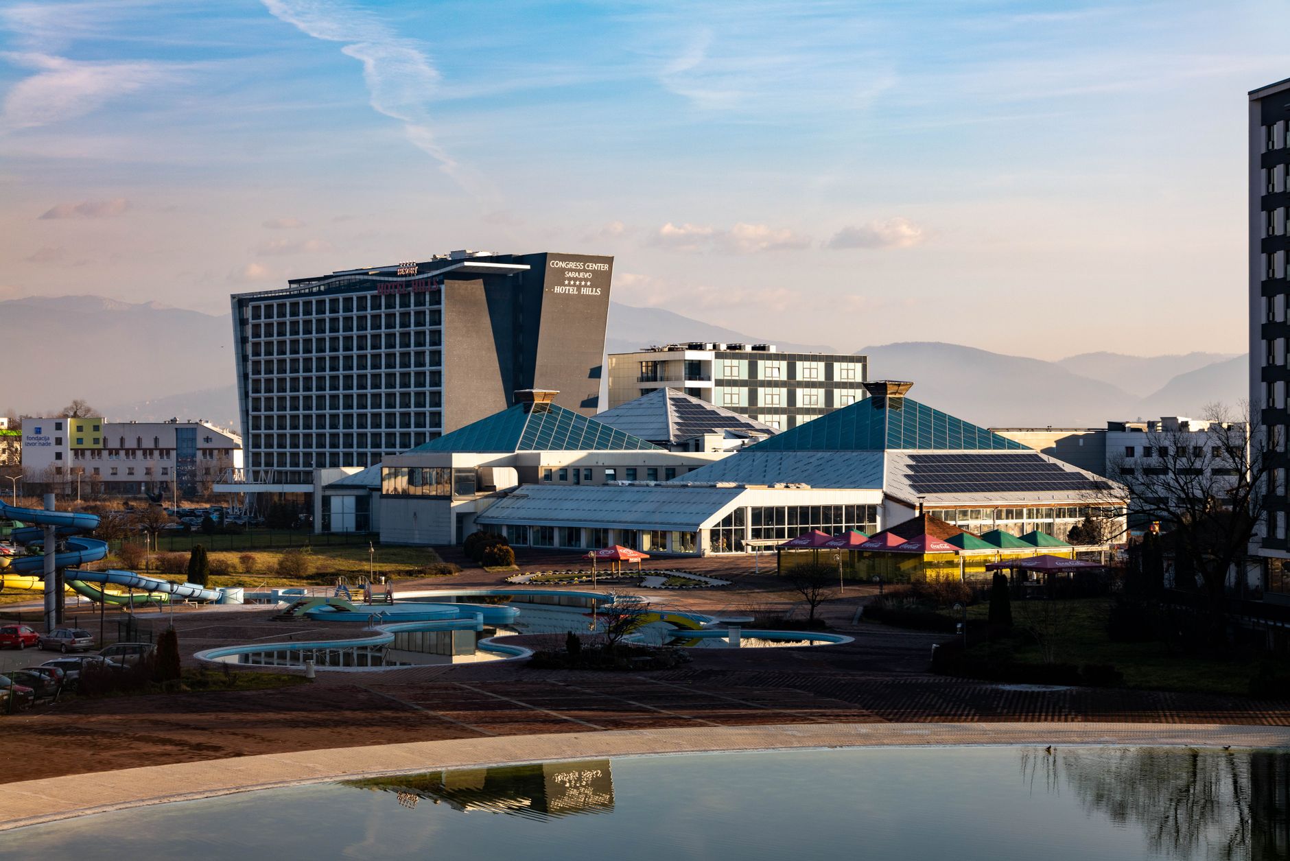 View of a modern thermal resort in Afyonkarahisar, featuring pools, slides, and serene gardens.