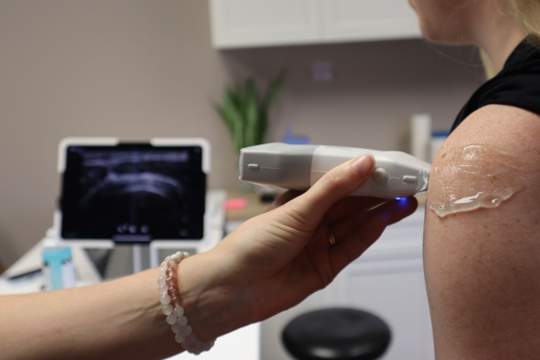 A radiologist uses an ultrasound probe on a patient's neck, initiating a diagnostic procedure.
