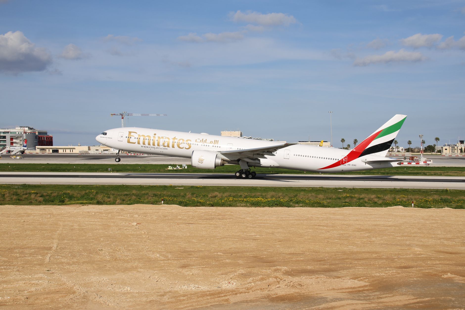 An Emirates Airlines Boeing 777 taking off at an airport in Türkiye.