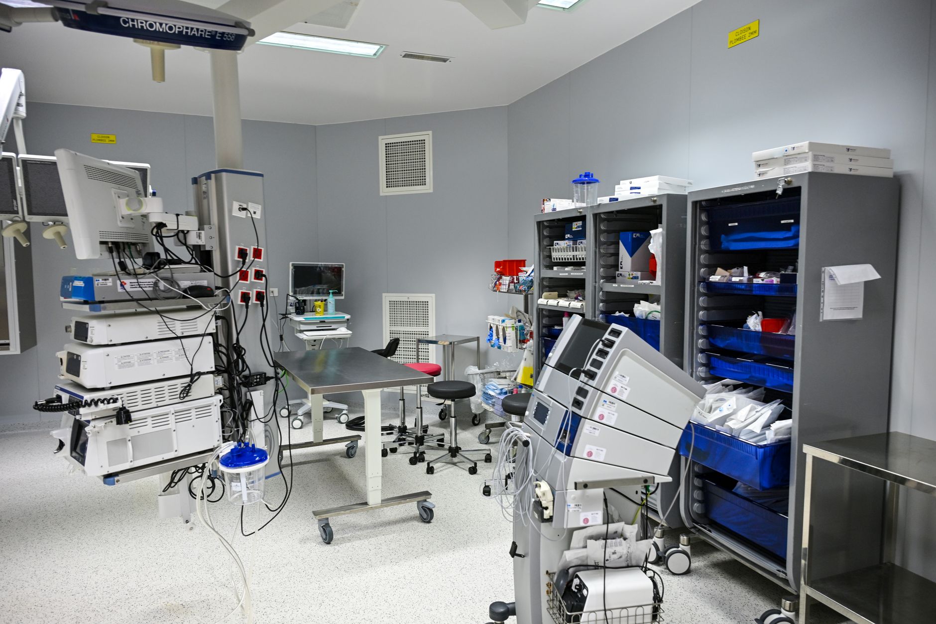 An advanced medical room equipped with robotic surgery systems and storage units.