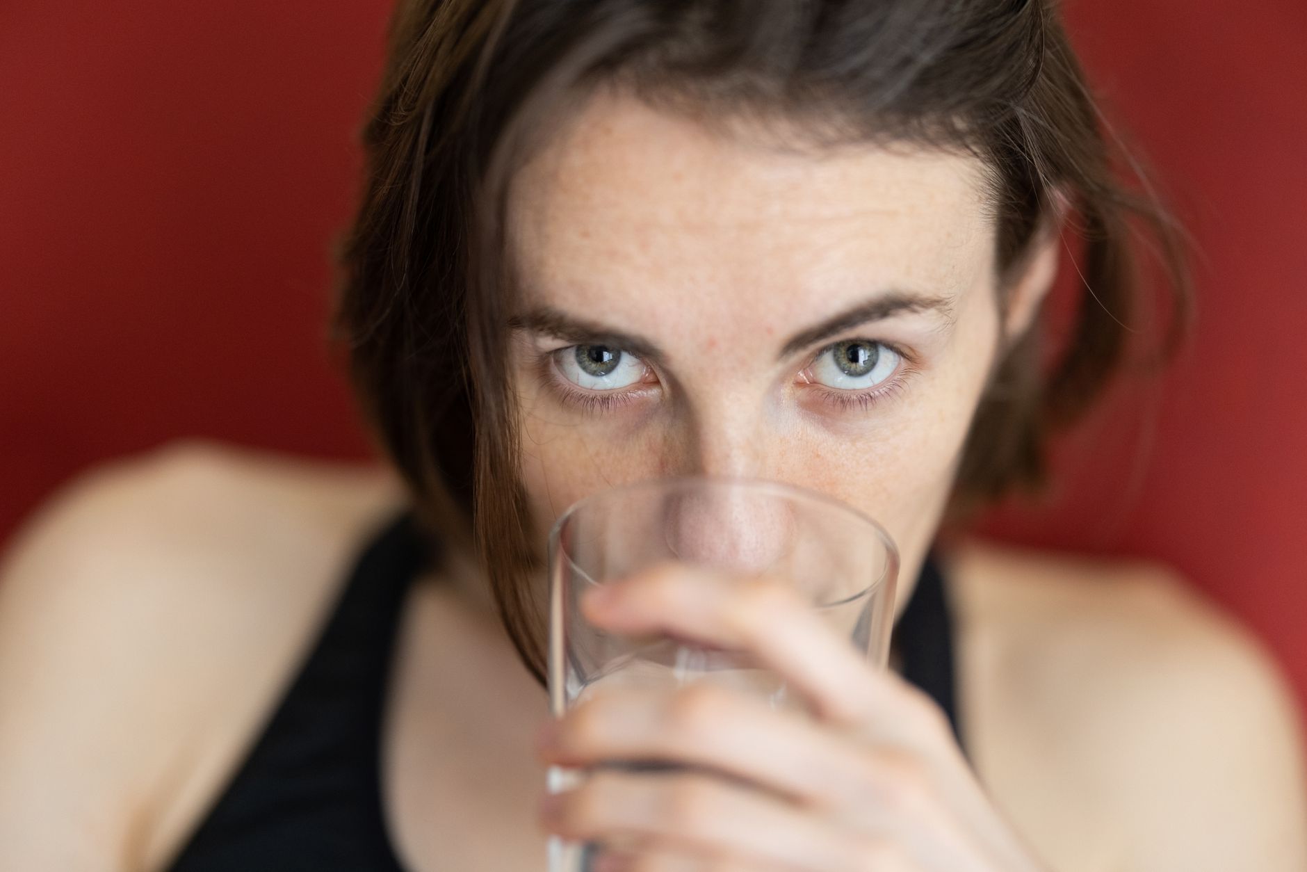 Close-up of a patient drinking water from a glass, promoting hydration.