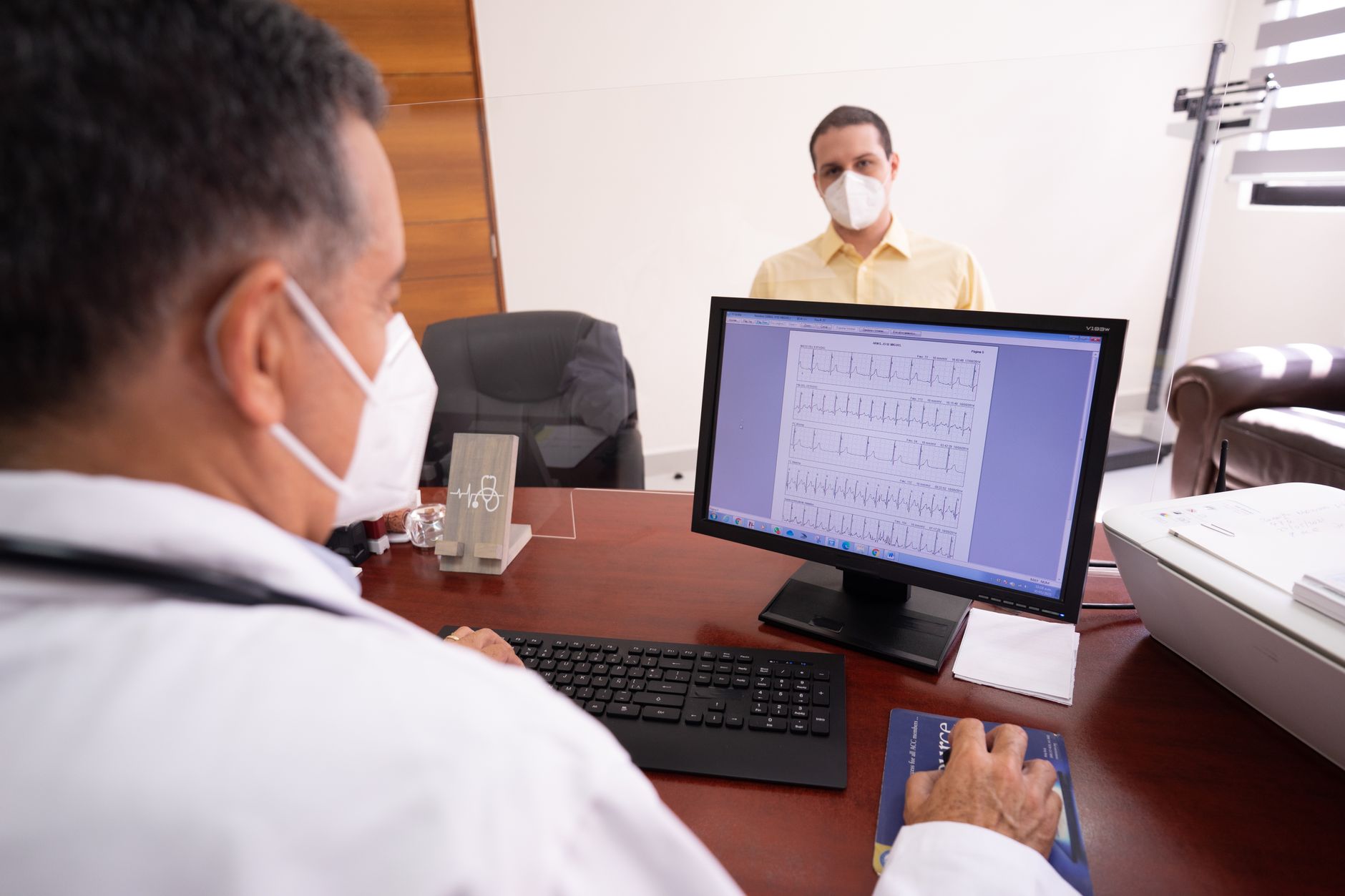 A bilingual physician explains ECG results to a patient during a consultation.