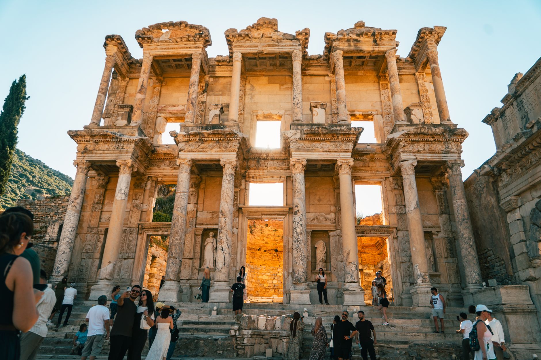 Ziyaretçiler Türkiye'de Efes'teki ikonik Celsus Kütüphanesi kalıntılarını geziyor.
