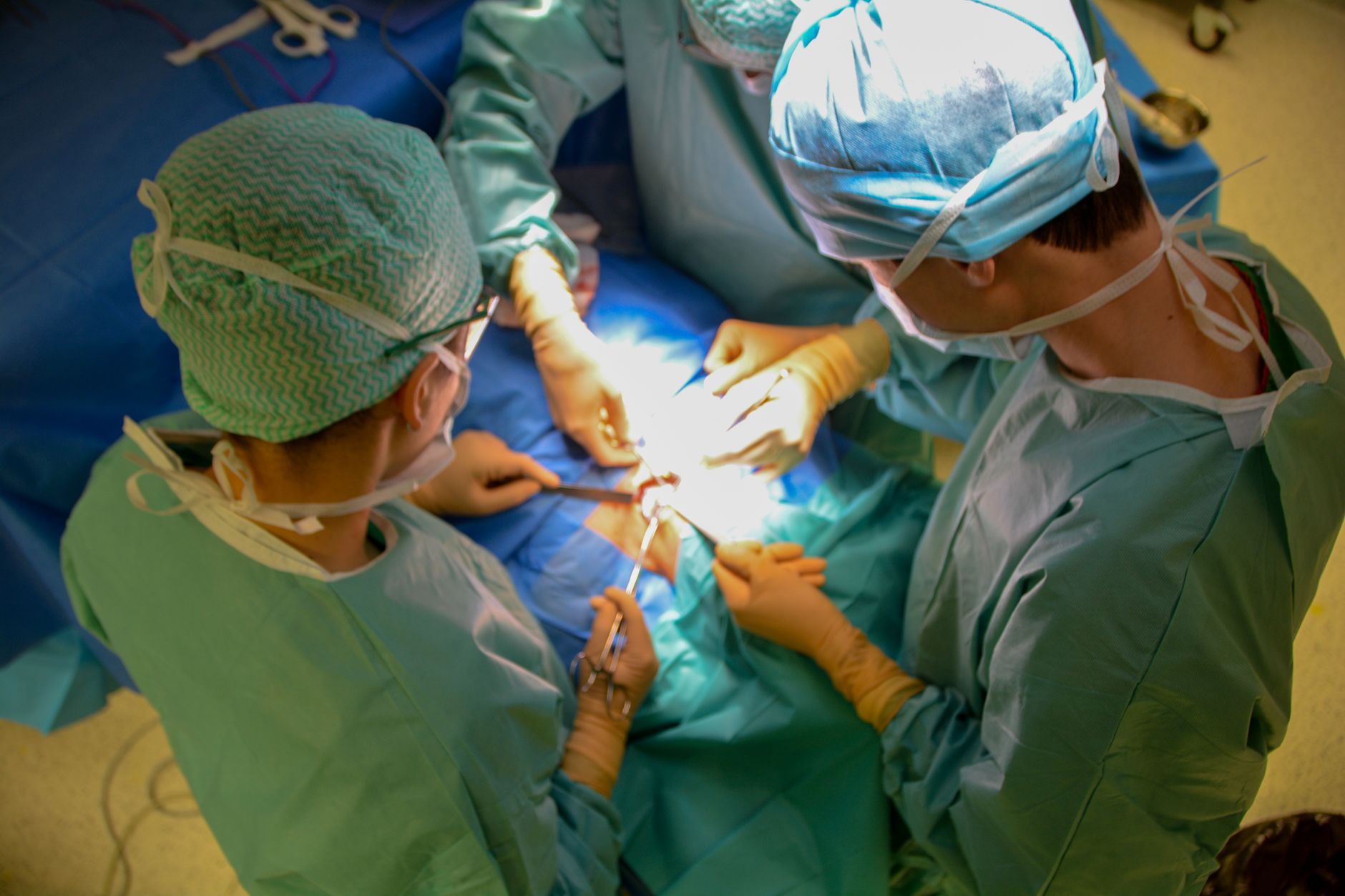 A multidisciplinary surgical team conducting an organ transplant procedure in a high-tech operating room.