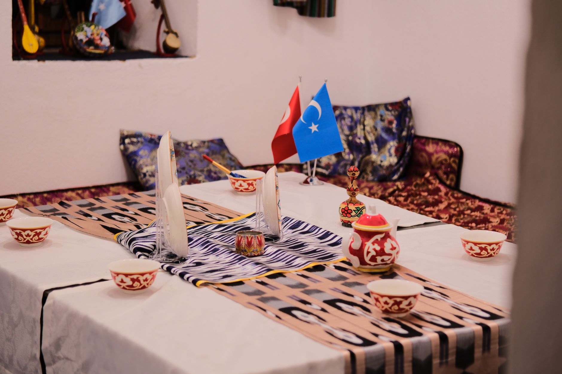 جلسة ترحيب تركية دافئة مع أعلام وأواني مزخرفة ووسائد ملونة في منزل ييلا.