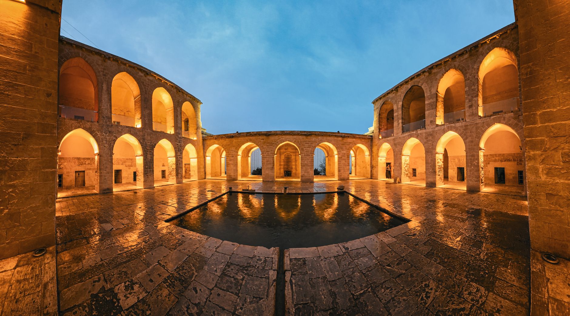 Interior courtyard of the historic Sultanhanı Caravanserai with arches and a reflective pool.