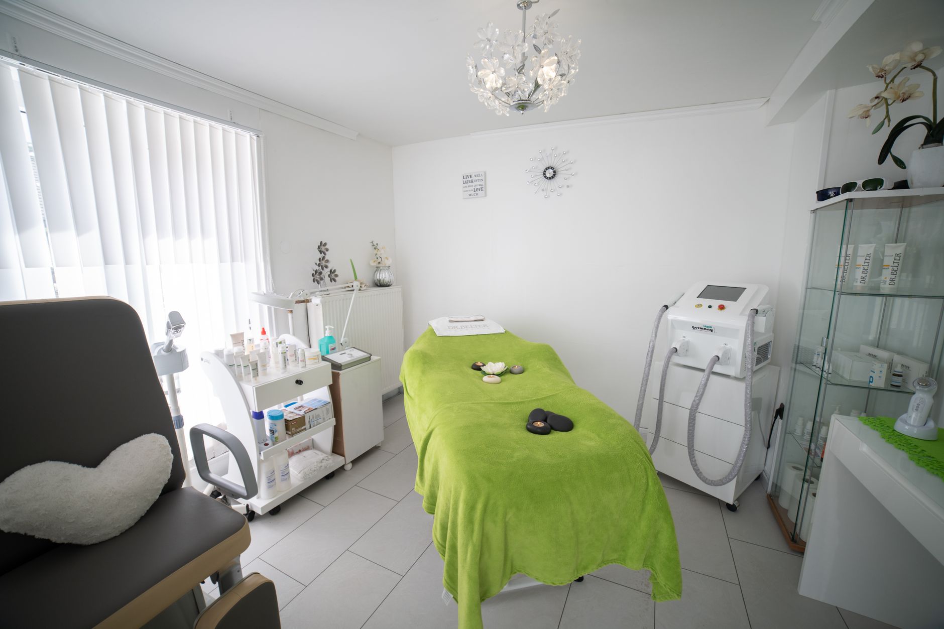 A bright phototherapy cabin featuring a green treatment bed and medical equipment.